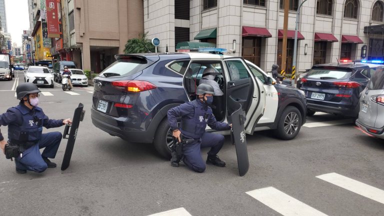 ▲圖說：員警接獲銀行搶劫通報後，荷槍實彈抵達銀行大門前戒備 （圖／台中市政府提供）
