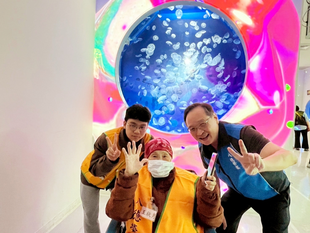 在五彩繽紛的水母展區前 住民與酆世俊主任右1合影留念 流光幻彩的背景映照出大家愉悅的笑容_Fotor - 報新聞 Mega News