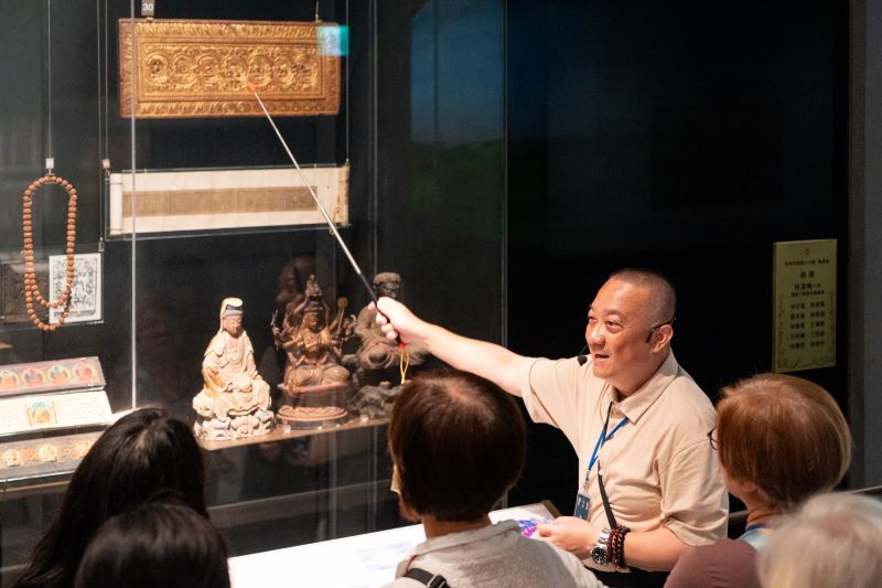 宗博館掌櫃講堂談藏傳淨土 葉靈毅帶讀《極樂願文》 56 《圖說》藏傳佛教研究者葉靈毅在世界宗教展示大廳導覽佛教展櫃。〈宗博館提供〉
