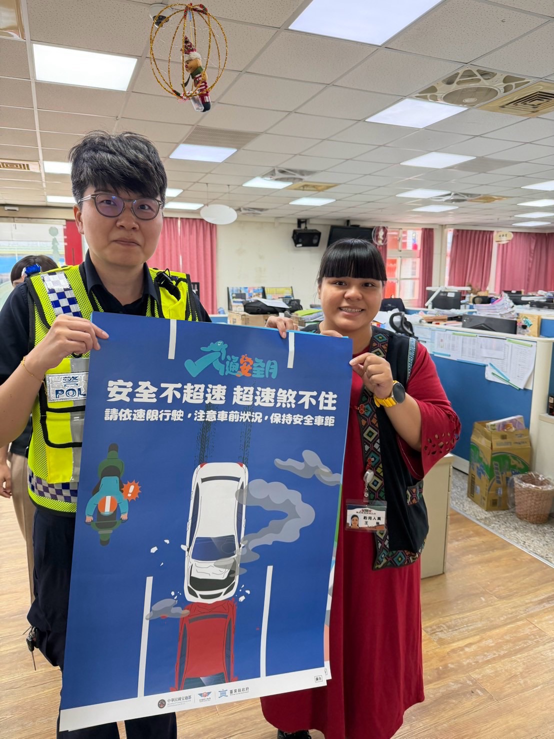 員警與民眾手持「安全不超速」交通安全宣導海報