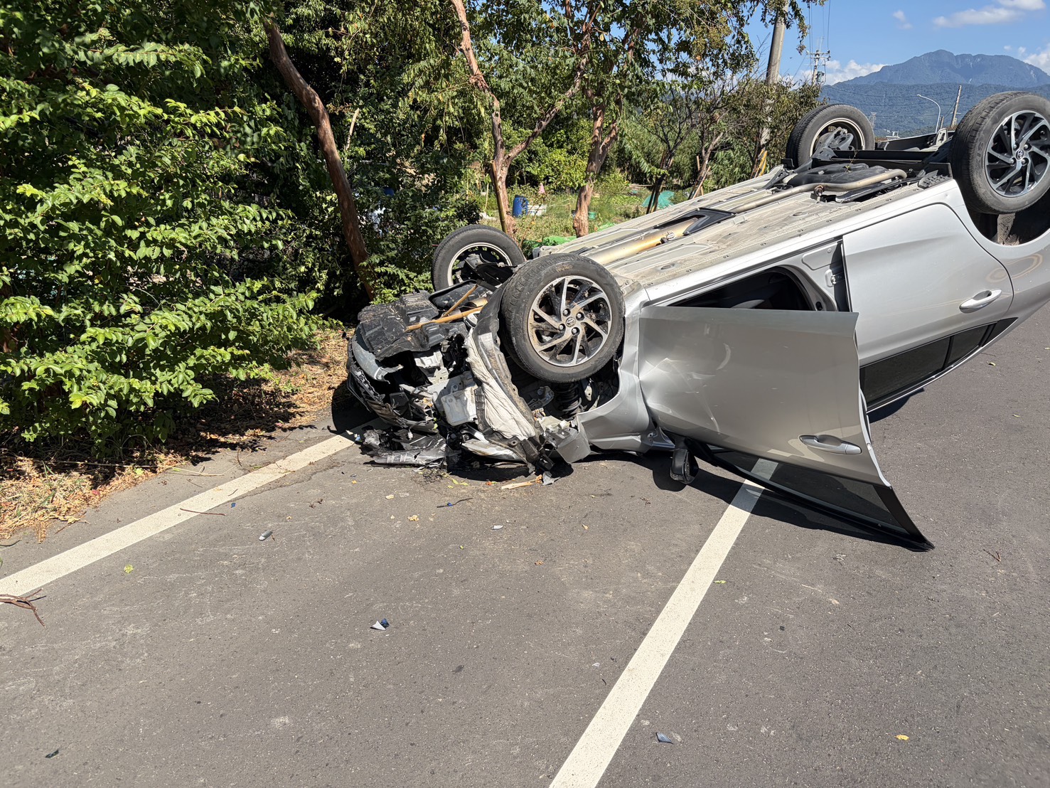 自小客車擦撞路樹後翻覆，車頭嚴重受損