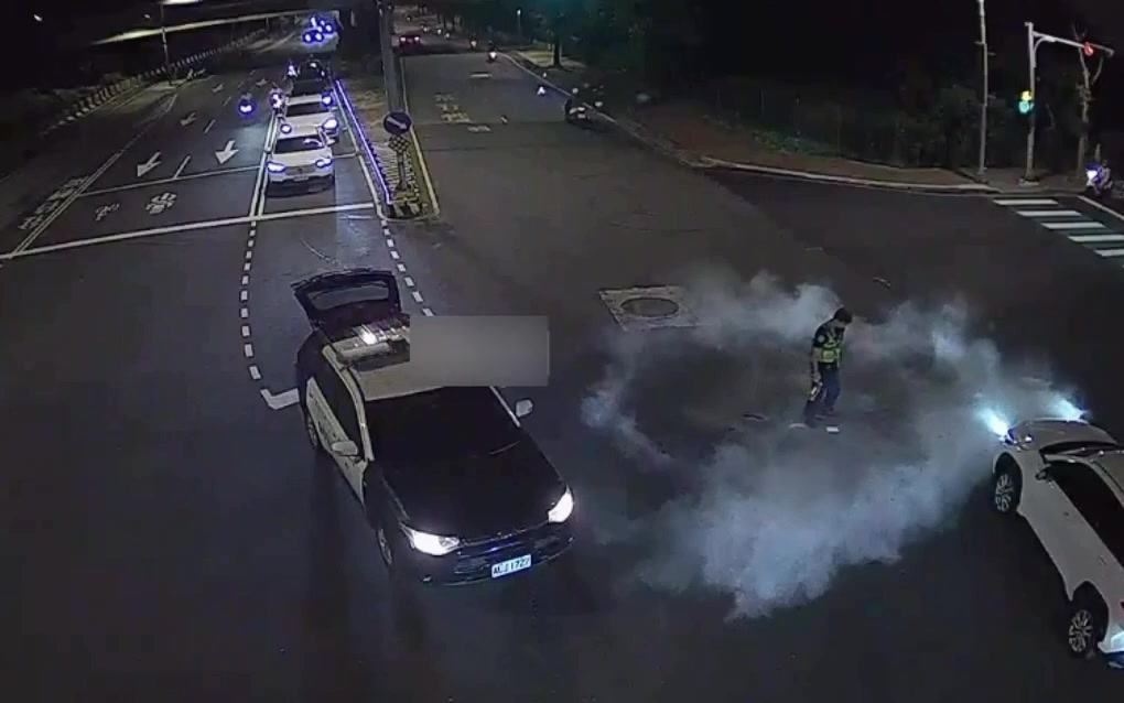 員警以巡邏車上滅火器處置路中冒煙的手機