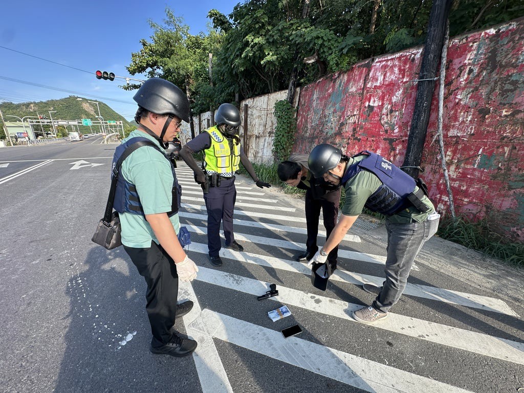 員警檢視歹徒遺留的槍枝與贓款(演練)
