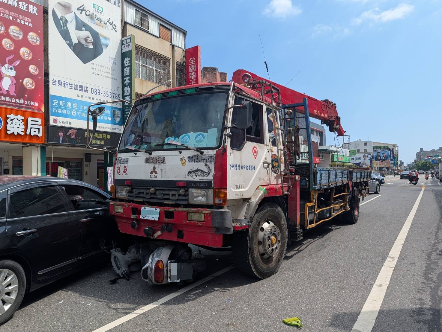大貨車車頭下方卡著機車