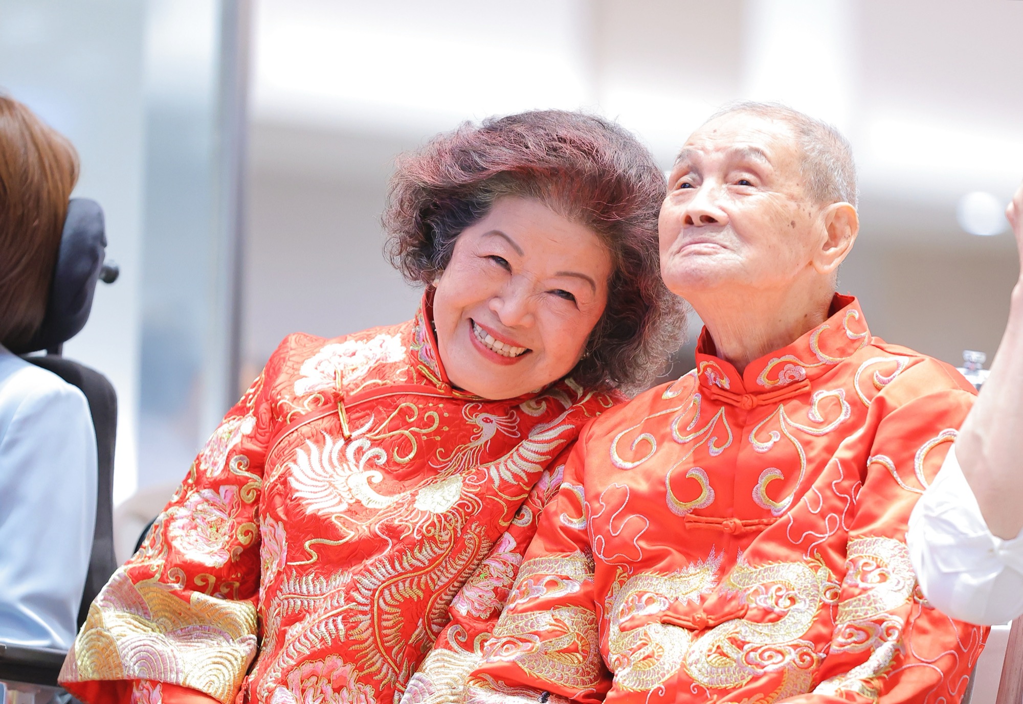 身穿龍鳳褂的白金婚佳偶甜蜜依偎