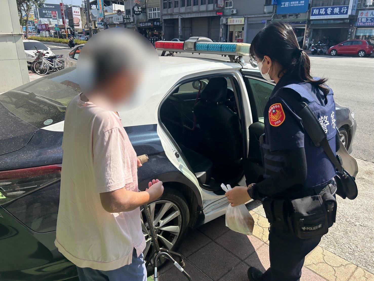 員警協助婦人上巡邏車