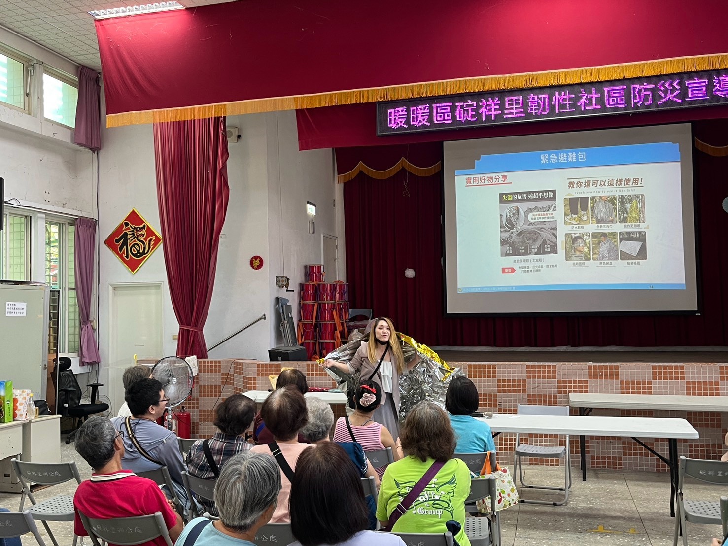講師示範緊急避難包內的保溫毯用法