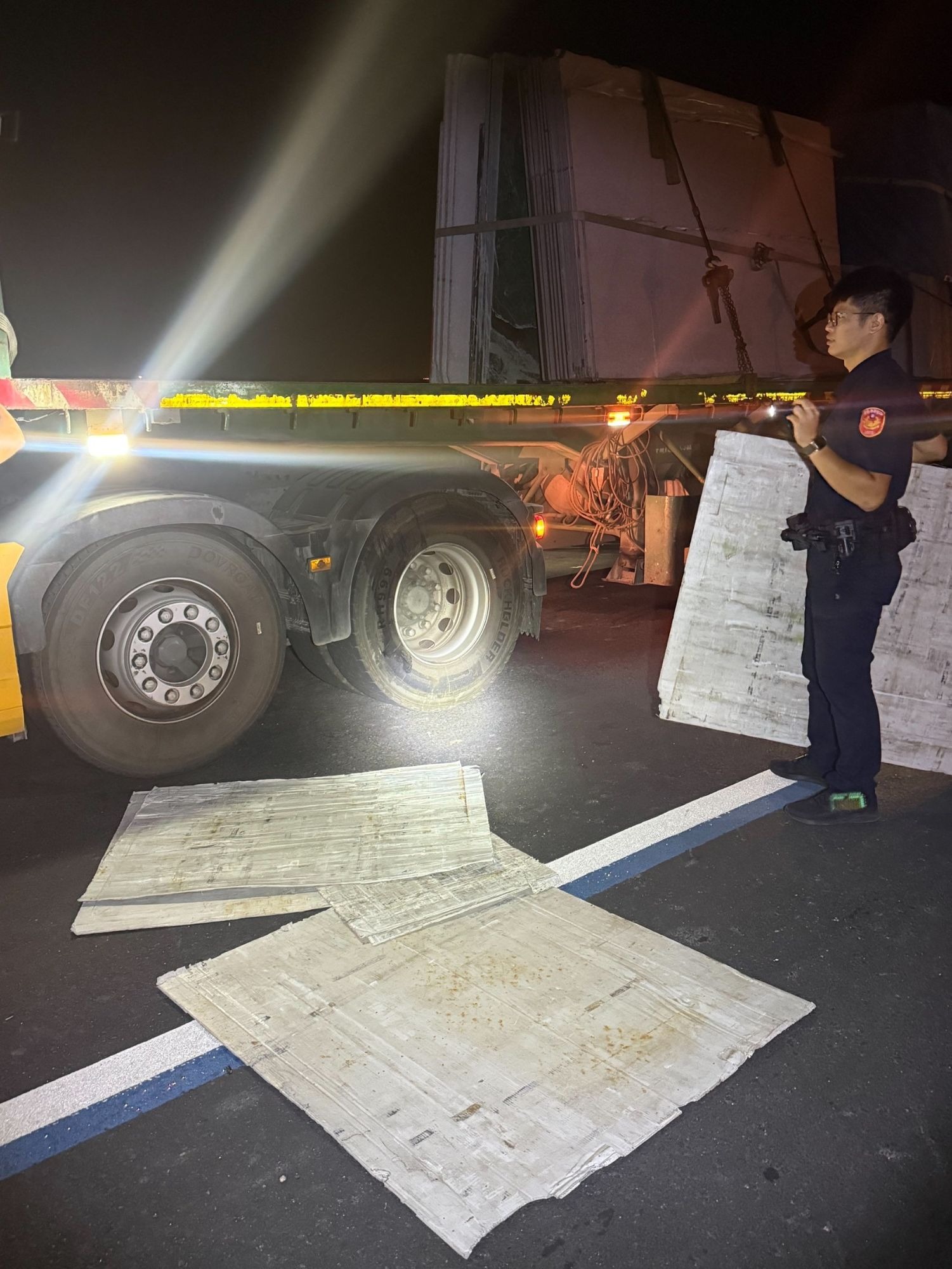 員警協助將散落路面的紙板搬回貨車