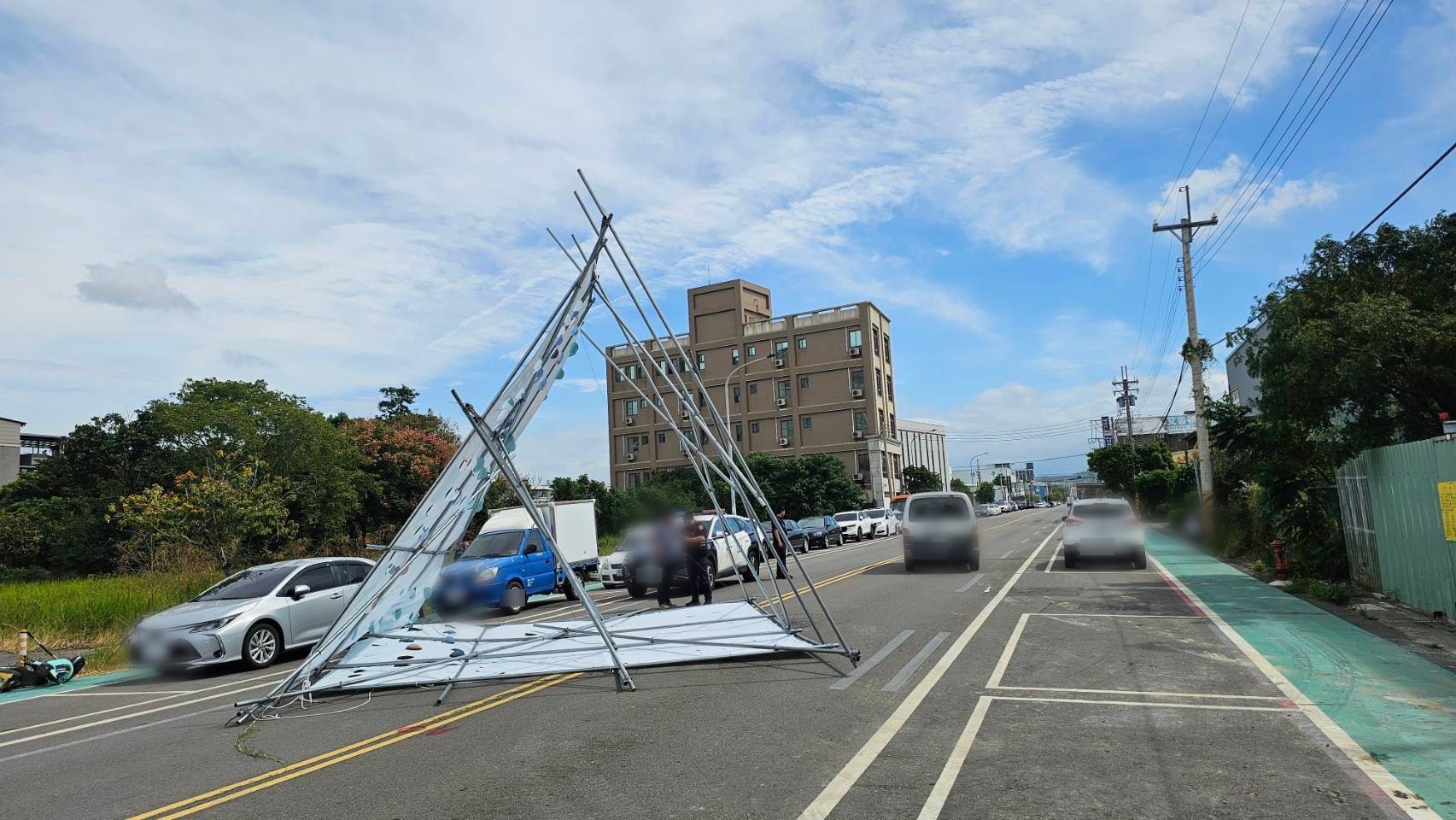 竹南鎮真如路大型看板遭強風吹倒橫躺道路