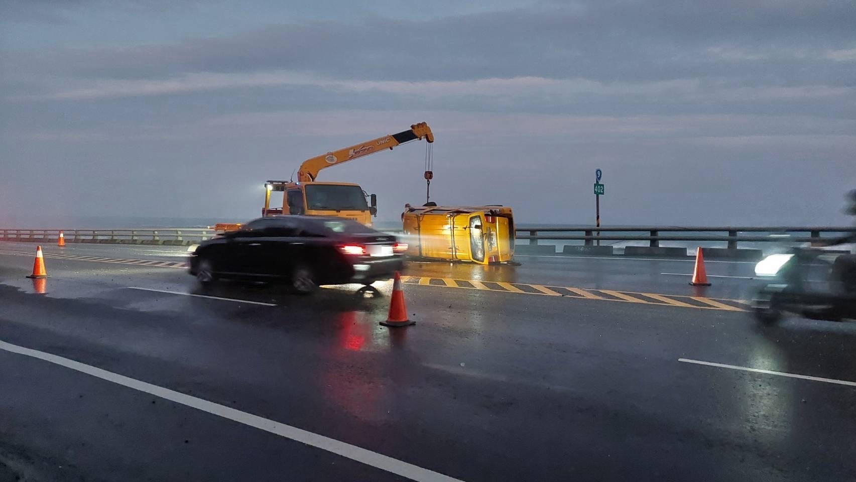吊車到場協助拖吊翻覆工程車