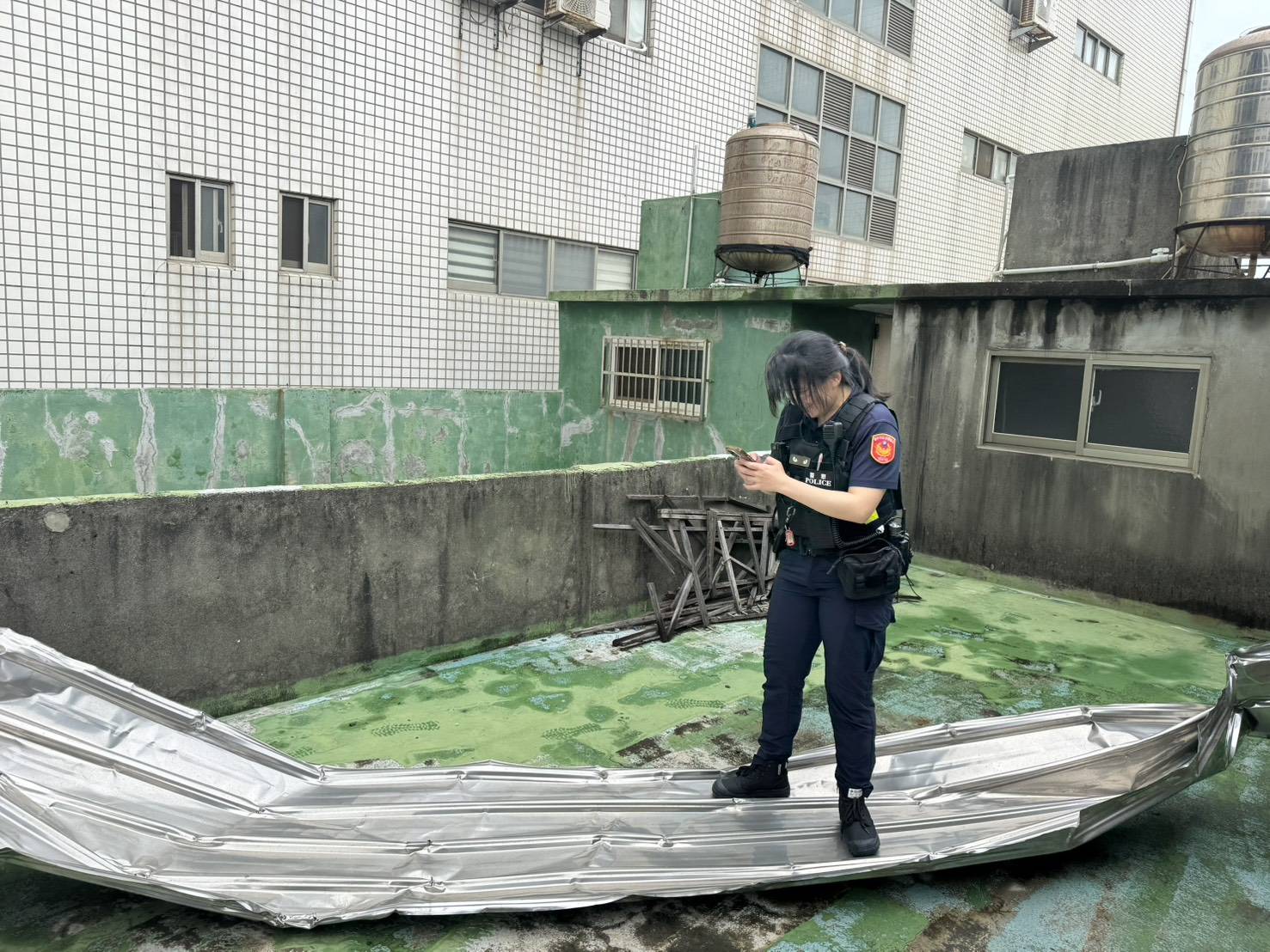 梧棲派出所員警於頂樓查看掉落鐵皮