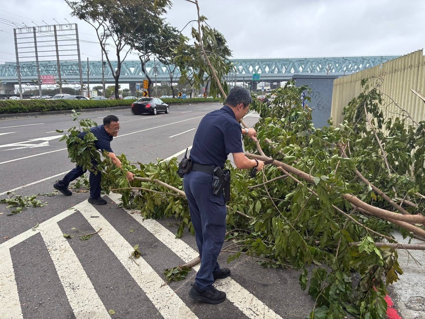 烏日分局員警頂著強風分段切鋸清理倒樹