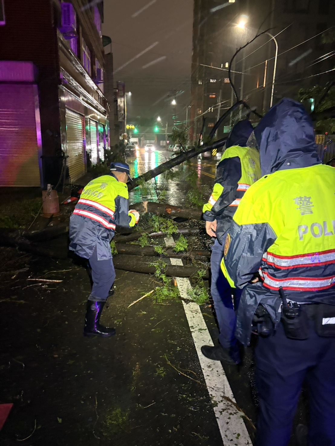 頭份派出所員警冒雨將倒塌路樹鋸斷排除