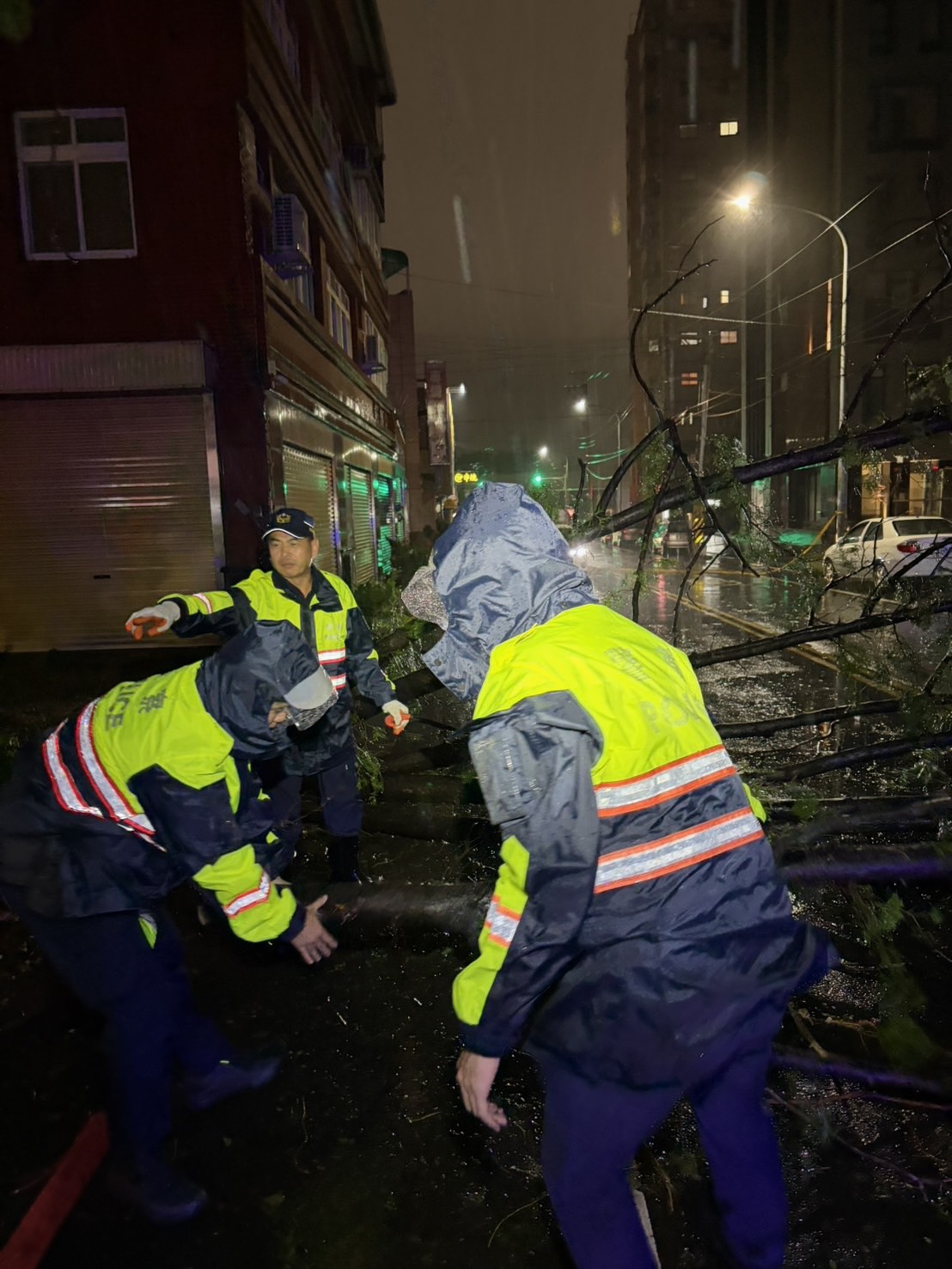 員警合力將路樹分段搬移至路旁安全區域