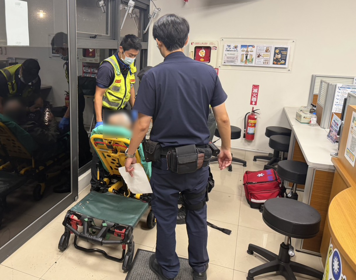 員警段浩維協助救護人員將老翁送醫