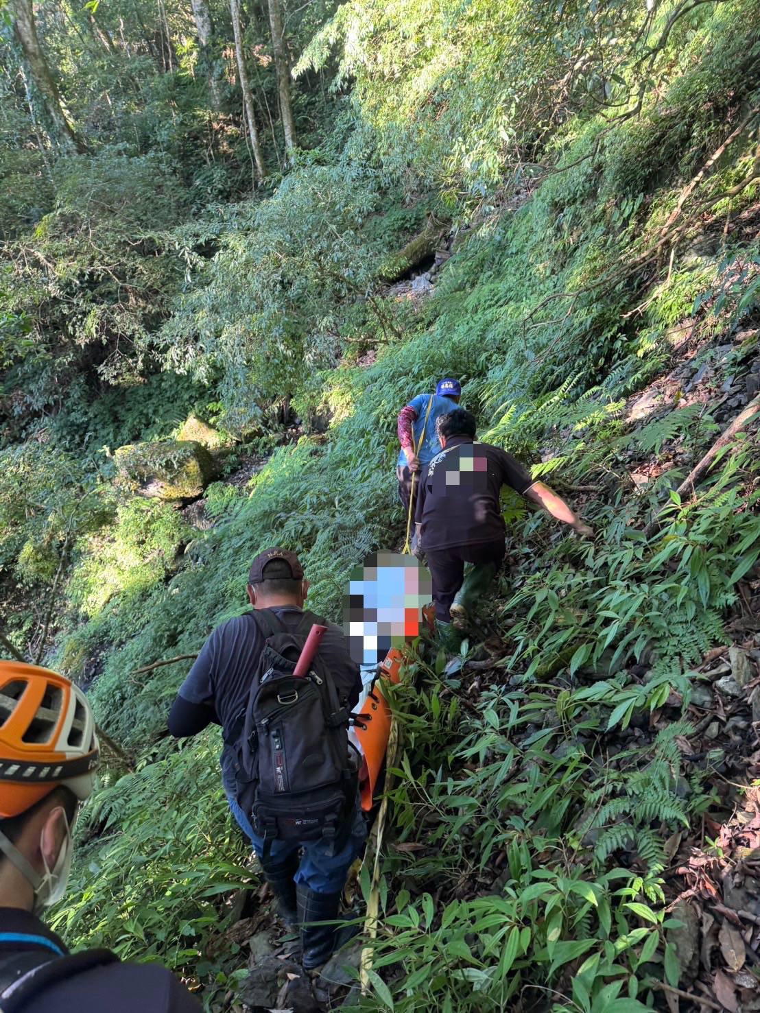 警方會同義警、義消及葬儀社人員,沿陡峭山坡將遺體搬運下山