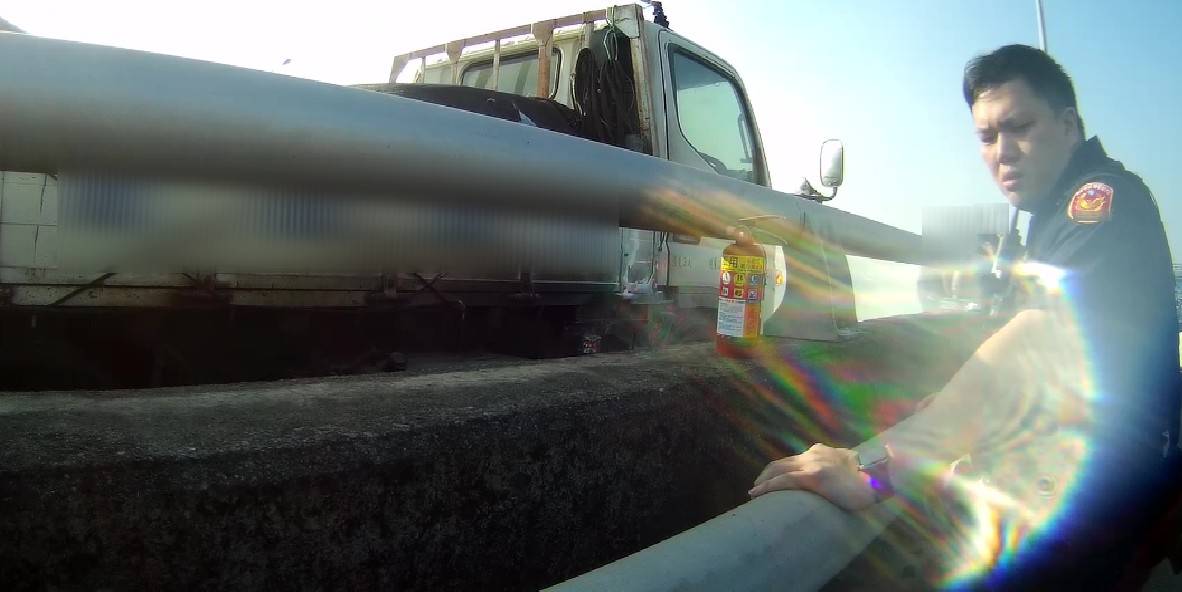 員警以巡邏車上備有的滅火器上前協助滅火
