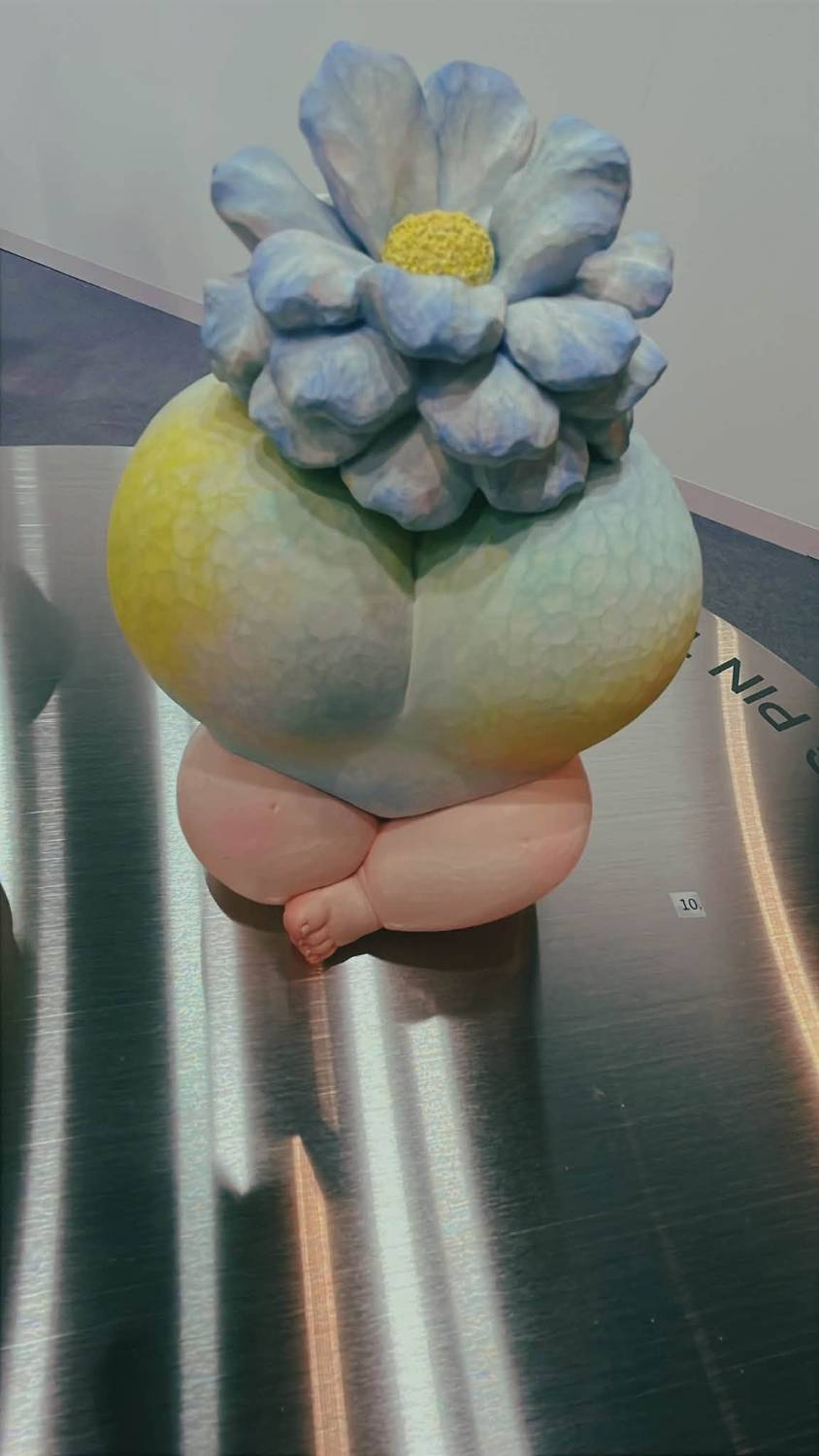 頭頂藍花的嬰兒腿雕塑