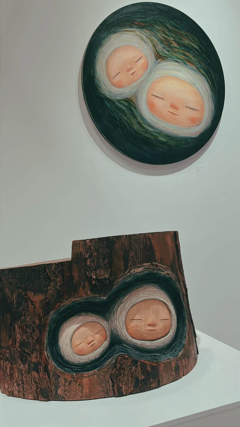 樹幹木雕與圓形畫作中熟睡的兩個嬰孩
